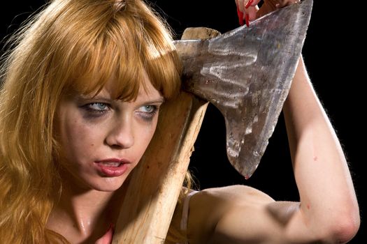 dark bizarre portrait of wild redhead girl with axe