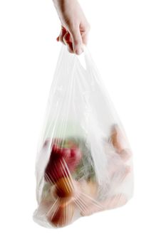 A clear plastic grocery bag filled with vegetables, a healthy choice