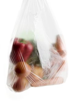 A clear plastic grocery bag filled with vegetables, a healthy choice
