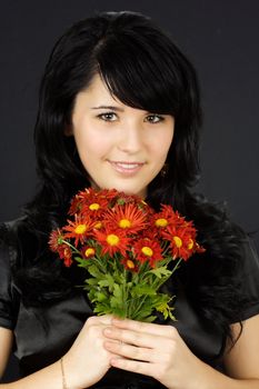 young woman with red daisies, black background