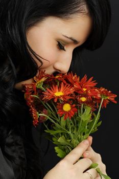 portrait of a young caucasian woman smelling daisy flowers