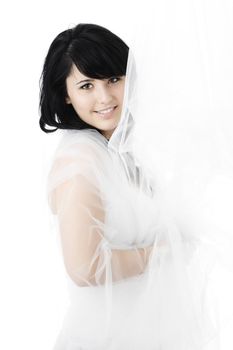 young woman hiding behind tulle fabric