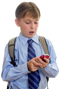 A schoolboy student using a mobile cell phone is sms or texting.  White background.