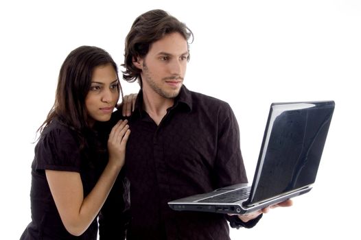 young couple looking into laptop on an isolated background