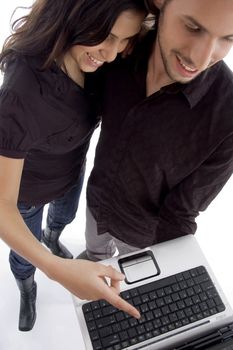 standing young couple looking into laptop with white background
