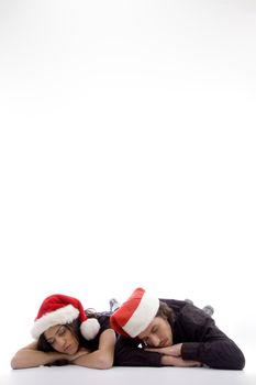 two friends lying on the floor with christmas hat on an isolated white background
