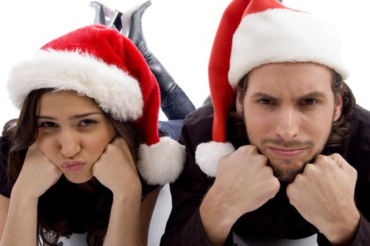 close up view of young couple wearing christmas hat and looking at camera against white background