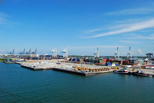 port of miami cargo and containership area depicting tugboats and heavy equipment and loading cranes