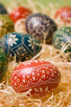 Handmade easter eggs on the shavings. Selective focus, shallow depth of field.