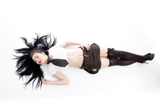 beautiful young woman lying on her back against white background