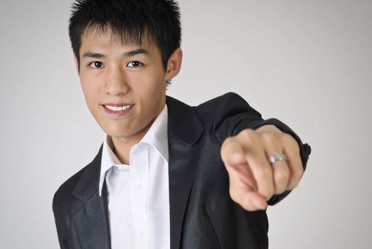 Young business man pointing out towards you with smiling face.