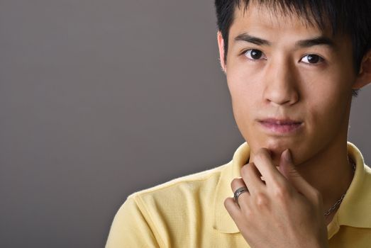 Portrait of young handsome man of Asian thinking and watching.