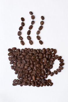 Coffee cup sign made of coffee seeds on the white table-cloth. Clipping path included.