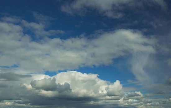 In the blue sky translucent stratose and cumulus clouds