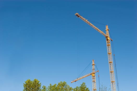 two hoisting cranes and the sky