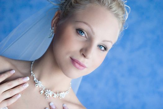 a bride puts on a necklace