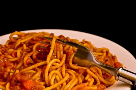 a plate of spaghetti bolognese with a fork