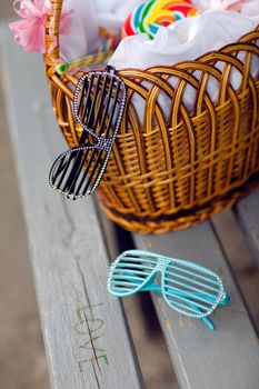 basket with candies and sunglasses on the bench