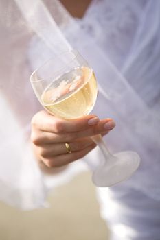 glass of champagne in a hand of a bride