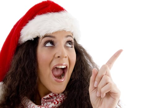 young woman with christmas hat indicating upward against white background