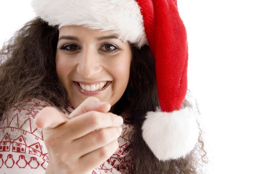 young female with christmas hat pointing at camera against white background