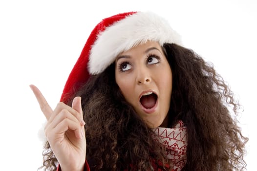 young woman with christmas hat pointing aside on an isolated white background