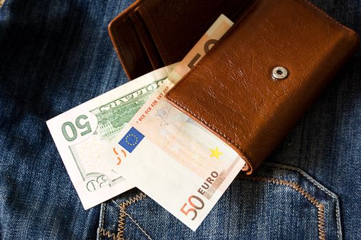 Fifty dollar and euro banknotes in wallet on jeans