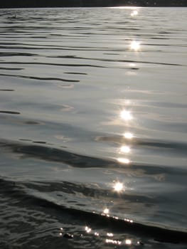 The sun reflects off the tranquil rippled waves on a Lake