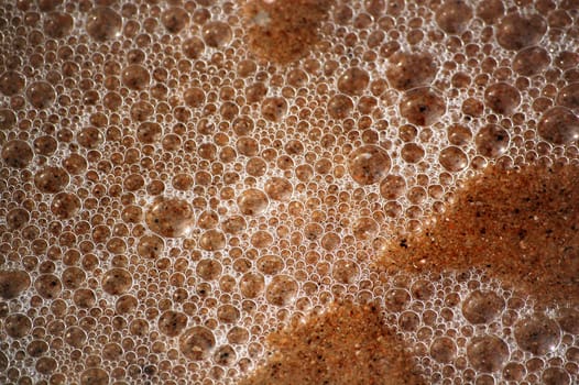 Texture of wet sand and ocean bubbles