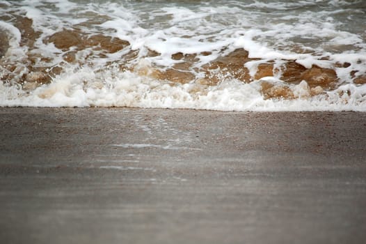 A small wave splash on the beach sand