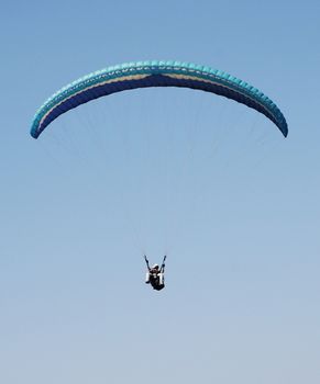 Double Paragliding flying through the sky above the ocean