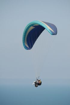 Double Paragliding flying throught the sky above the ocean