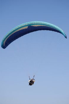 Double Paragliding flying throught the sky above the ocean