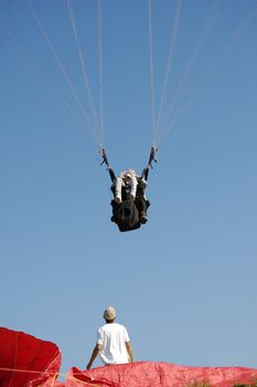 Double Paragliding landing with a men looking