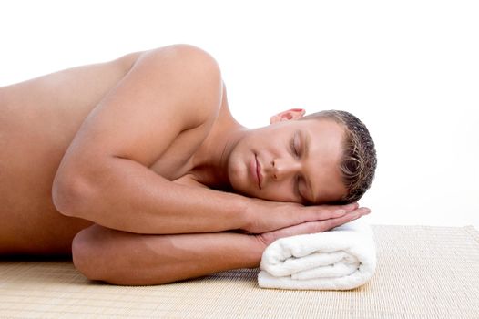 young male lying on mat ready to take spa treatment on an isolated white background