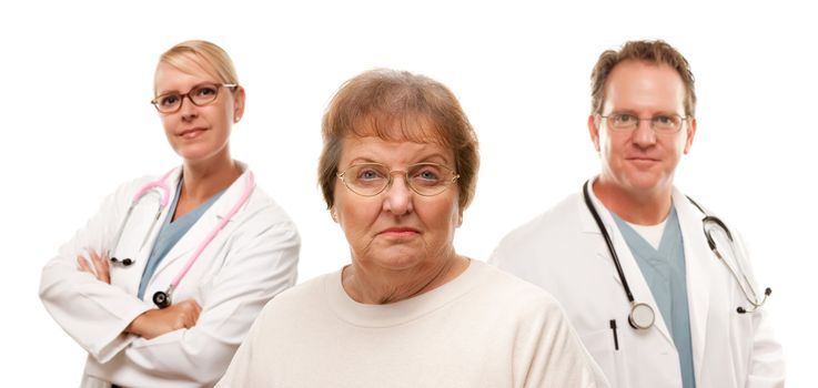 Concerned Senior Woman with Doctors Behind Isolated on a White Background.