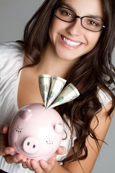 Beautiful smiling woman holding piggy bank