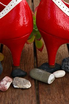 a pair of red high heels on top of pebbles