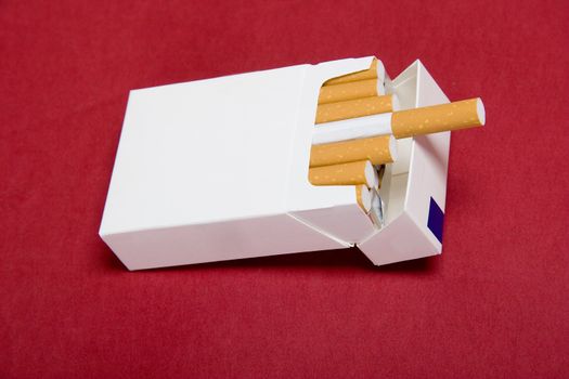 closeup of packet cigarettes on red background