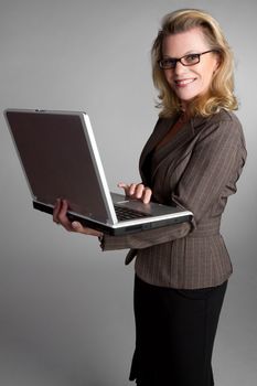 Smiling business woman holding laptop