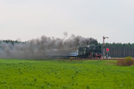 Old retro steam train passing through polish countryside
