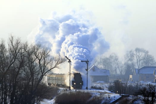 Vintage steam train starting from the station during wintertime