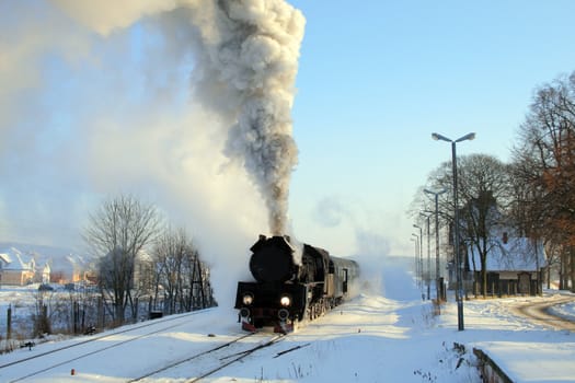 Vintage steam train starting from the station, wintertime