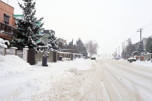 Snowy road leading through the village during wintertime