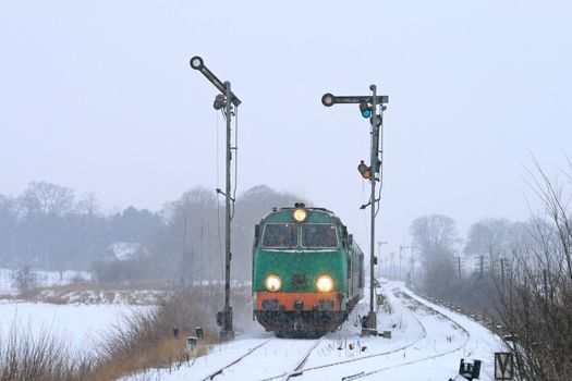 Passenger train starting from the station during wintertime
