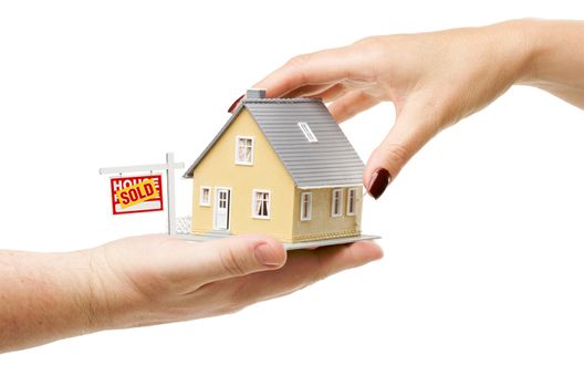 Reaching For A Home with Sold Real Estate Sign Isolated on a White Background.