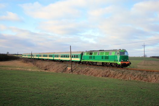 Rural landscape with train hauled by the diesel locomotive