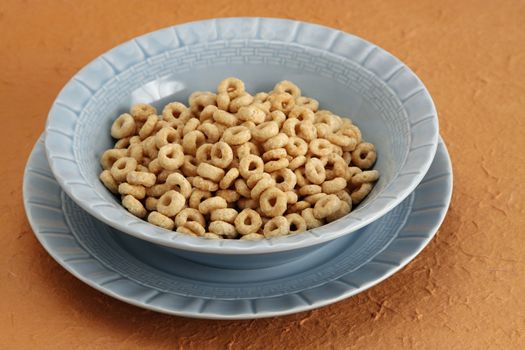 dry oat cereal in blue bowl