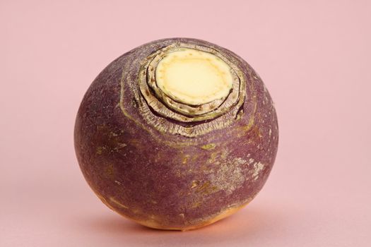 fresh whole raw turnip, pink background