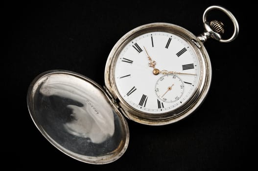 Elegant rusty pocket watch, isolated on black